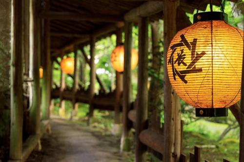 a lantern with writing on it hanging from a bridge at Yumoto Choza in Takayama