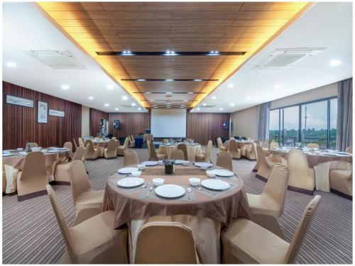 a conference room with tables and chairs and windows at Amphawa Nanon Hotel in Amphawa