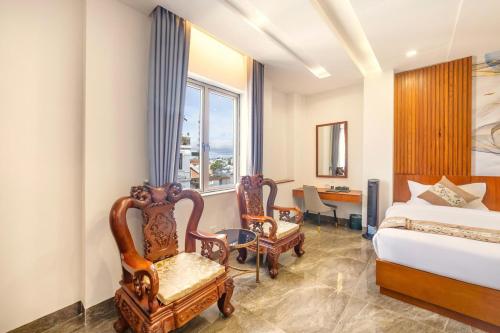 a bedroom with a bed and two chairs and a desk at Royal Palace in Da Lat