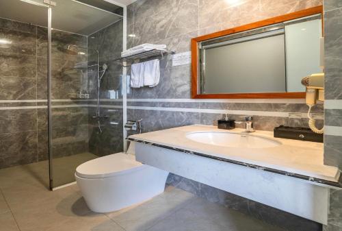 a bathroom with a toilet and a sink and a shower at Royal Palace in Da Lat