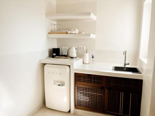 a small kitchen with a sink and a refrigerator at Pilos Suites in Turunc