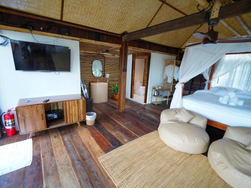 a bedroom with a bed and a tv and a couch at RoomQuest THEVA Resort Koh Samui in Koh Samui 