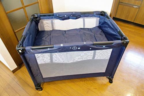 an open suitcase is sitting on a wooden floor at Tokyo Kitasen 4 in Tokyo