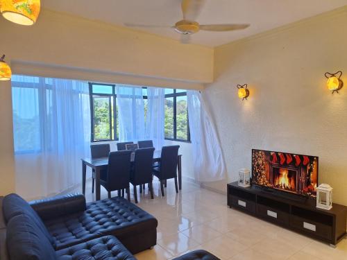 a living room with a table and a fireplace at Seaput Srisayang in Batu Ferringhi