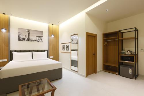 a bedroom with a large bed and a glass table at Pride Premier Solitaire in Dehradun