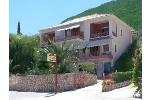 a house with a palm tree in front of it at Christianna studios in Nikiana