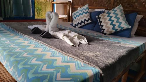 a bed with a stuffed animal laying on it at Apo Diver Beach Resort in San Juan