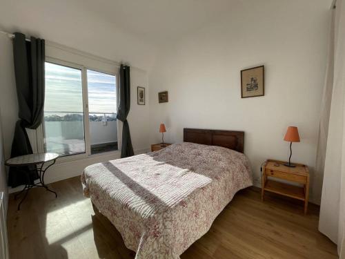 une chambre avec un lit et une grande fenêtre dans l'établissement Appartement BELLE VUE MER sur la baie de Trestraou à PERROS-GUIREC - Réf 913, à Perros-Guirec