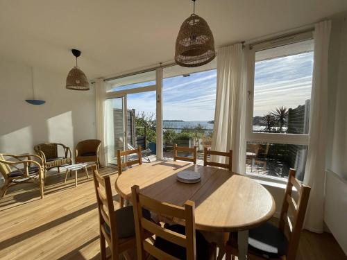 une salle à manger avec une table et une grande fenêtre dans l'établissement Appartement BELLE VUE MER sur la baie de Trestraou à PERROS-GUIREC - Réf 913, à Perros-Guirec