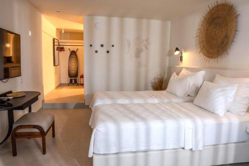 a hotel room with a large white bed and a desk at Pilos Suites in Turunc