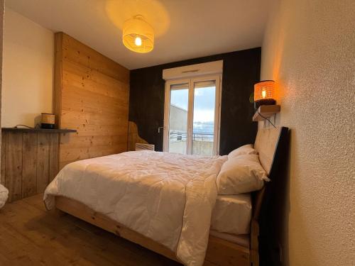 a bedroom with a large bed with a window at Appartement lumineux avec piscine et parking à Évian - FR-1-498-109 in Évian-les-Bains