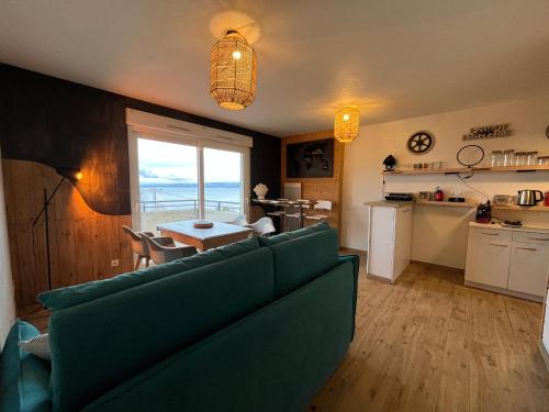 un salon avec un canapé vert et une cuisine dans l'établissement Appartement avec piscine et parking à Évian-les-Bains - FR-1-498-109, à Évian-les-Bains