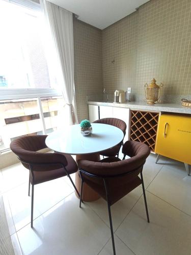 a kitchen with a table and chairs in a kitchen at Ap Luxo e Requinte em Guarapari in Guarapari