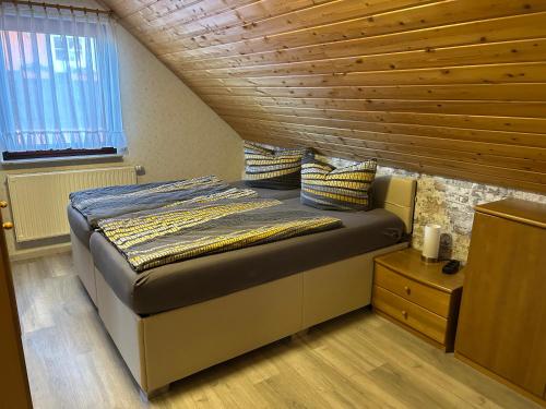 NohraにあるFerienwohnung Familie Putschkeの木製の天井の客室のベッド1台分です。