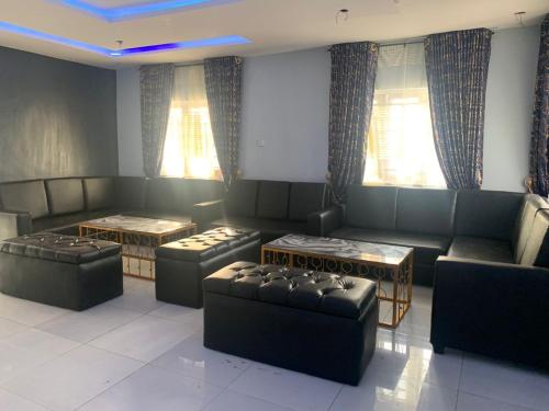 a living room with couches and tables and windows at Umbrella Properties hotels and apartments - Moniya in Ibadan