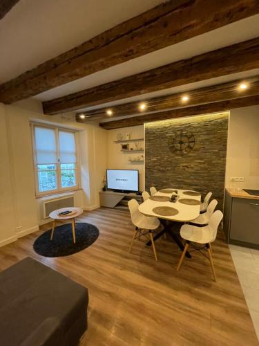 - un salon avec une table, des chaises et une télévision dans l'établissement Grand 5 pièces Petite France, à Strasbourg