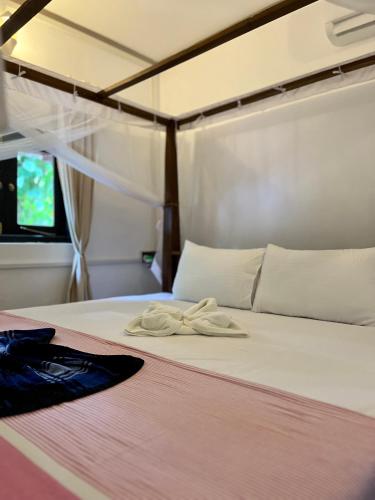a bed with two towels sitting on top of it at Jungle Nook Hiriketiya in Hiriketiya