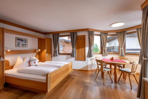 a hotel room with a bed and a table at Eden Appartements in Going