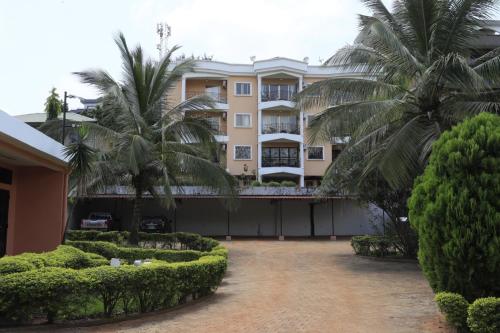 a building with palm trees in front of it at Residence La Marina in Yaoundé
