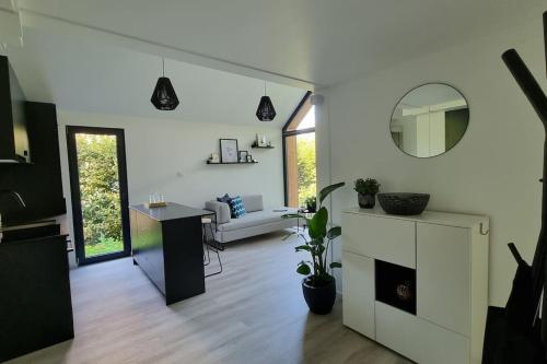 a white living room with a couch and a table at Kleinhauszeit Tiny House in Wohlen