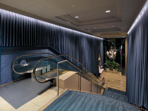 a staircase in a lobby with blue stripped walls at Princess Garden Hotel in Nagoya