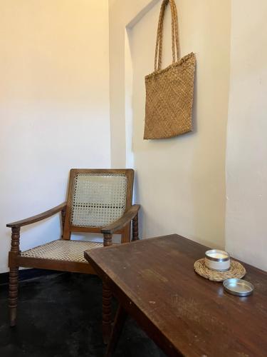 a room with a wooden table and a chair at Jungle Nook Hiriketiya in Hiriketiya