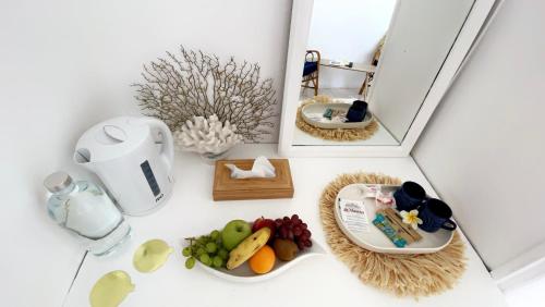 a table with a plate of fruit and a mirror at Cocoon Paradise in Flic-en-Flac