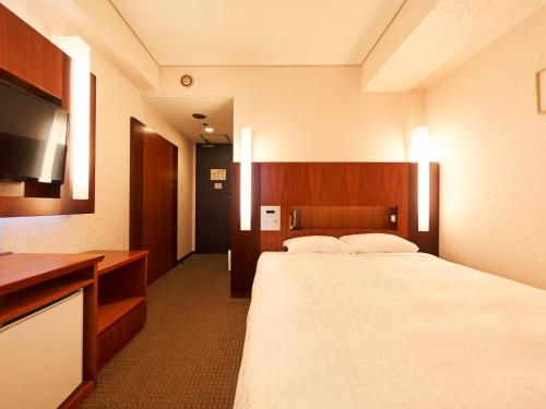 a hotel room with a bed and a flat screen tv at Princess Garden Hotel in Nagoya