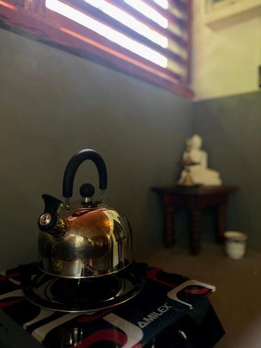 a tea kettle sitting on top of a stove at Jungle Nook Hiriketiya in Hiriketiya