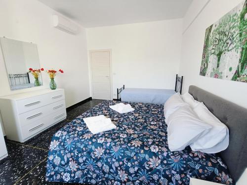 a bedroom with a bed with a blue floral bedspread at B&B Casa Scotto in Savona