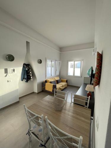 a living room with a table and chairs and a couch at Villa Nido dei Passeri in Calasetta