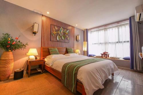 a bedroom with a large bed and a window at Secret Courtyard Resort Hotel in Guilin