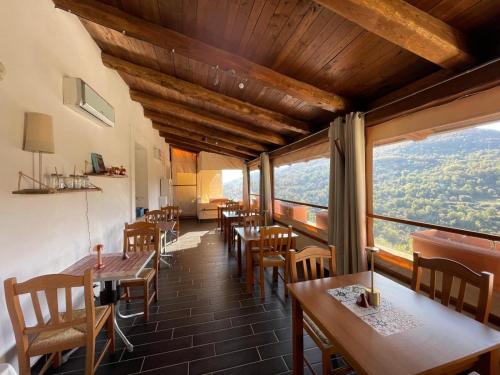a restaurant with tables and chairs and large windows at Palazzo del Baglivo Cilento Hotel & Spa in Sessa Cilento