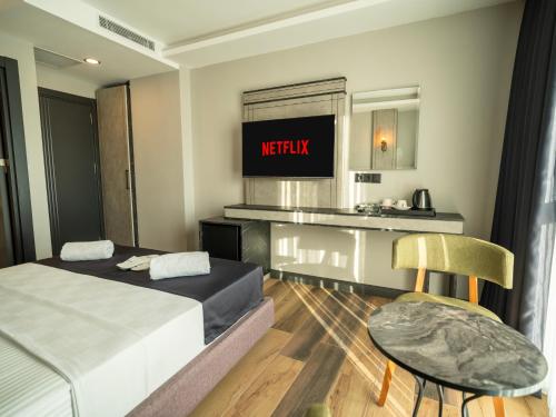 a hotel room with a bed and a table and chair at Comfort Point Three Hotel in Istanbul