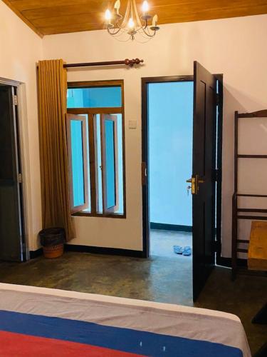 a room with two doors and a room with a bed at Backpack Beach Hostel & Reggae Bar in Galle
