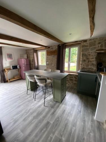 une cuisine avec une table et des chaises dans une pièce dans l'établissement Maison, à Ussel