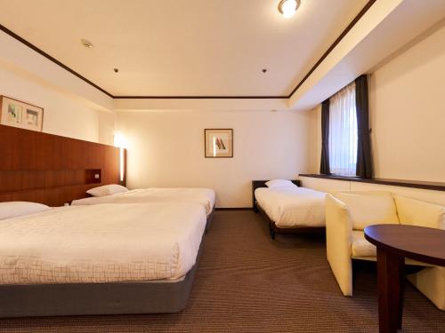 a hotel room with two beds and a table at Princess Garden Hotel in Nagoya