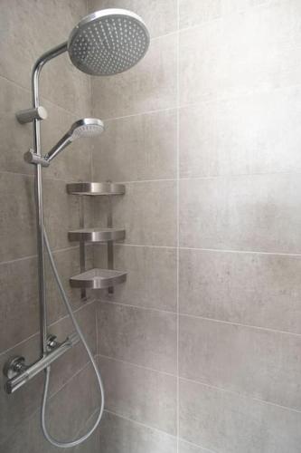 une douche avec pommeau de douche dans une salle de bain dans l'établissement Le Rayon Vert - Vue sur l'aiguille et garage priv, à Étretat