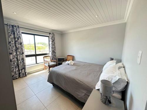 a bedroom with a bed and a large window at DIE Huis House in Wilderness