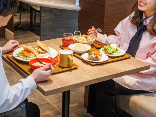 a group of people sitting at a table eating food at Princess Garden Hotel in Nagoya