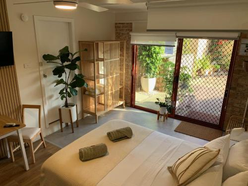 una camera da letto con un grande letto bianco in una stanza di Studio 327 a Woolgoolga