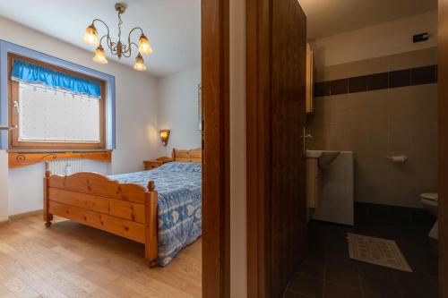 a bedroom with a bed and a bathroom with a window at Casa Riccardo in Soraga