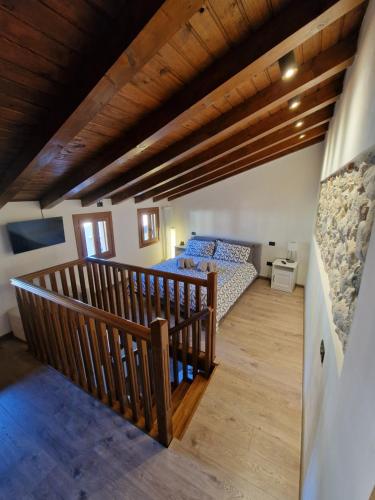 a bedroom with a bed and a wooden staircase at Il Vicoletto in Marostica