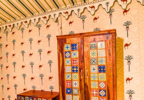 a room with a wall with palm trees and a wooden cabinet at Sia Resort in Sām