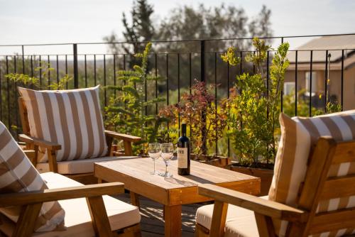 a table with a bottle of wine and two chairs at Mitzpe Ramon Desert Escape in Mitzpe Ramon