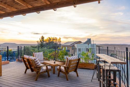 a deck with a table and chairs and a table at Mitzpe Ramon Desert Escape in Mitzpe Ramon