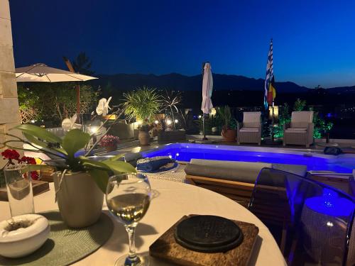 a table with a glass of wine on top of a patio at Villa athena Crète in Gavalochori