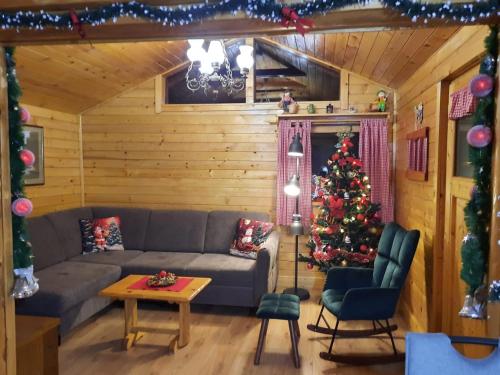 a living room with a christmas tree and a couch at Chalet Woody in Stara Sušica