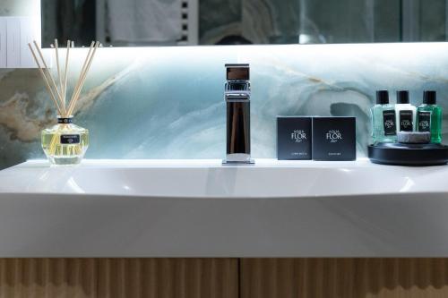 a bathroom sink with a bottle of perfume and a vase at Le Cinque Lampade Florence Suites in Florence