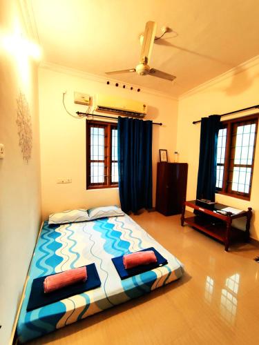 a bedroom with a large bed with blue and white at Jambavan Arts Sanctuary in Varkala